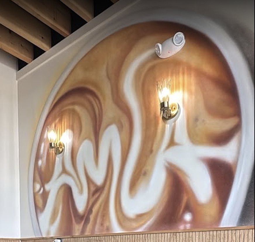 The caramel-swirl AMLA mural inside the cafe's modern lounge seating area